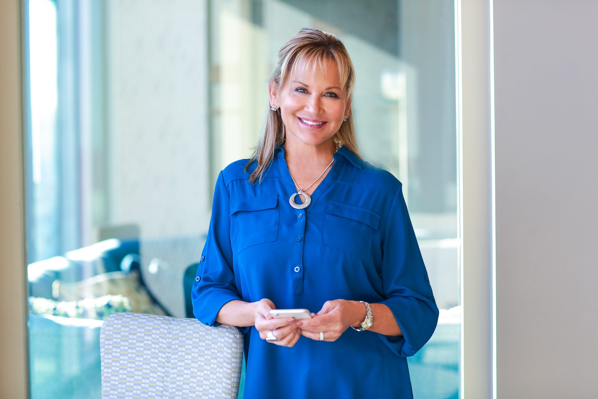 A woman in blue shirt holding a white object.